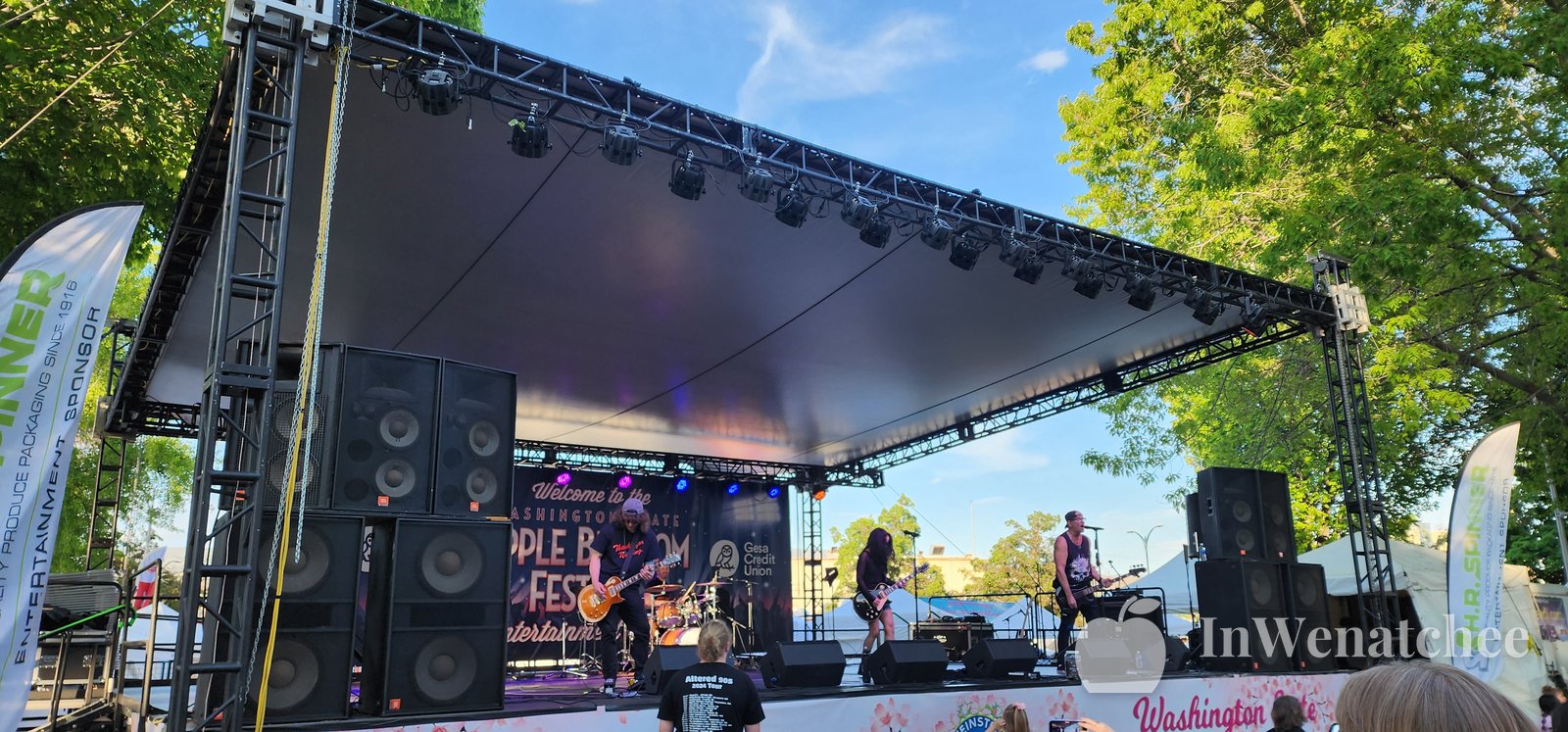 Wide view of the Apple Blossom 2026 entertainment stage with a band playing under the lights