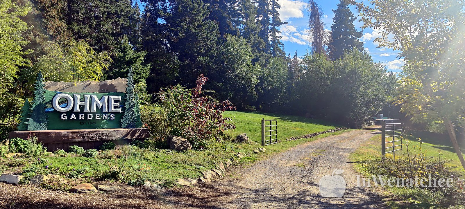 The Ohme Gardens entrance sign, with the gravel drive and trees beyond.
