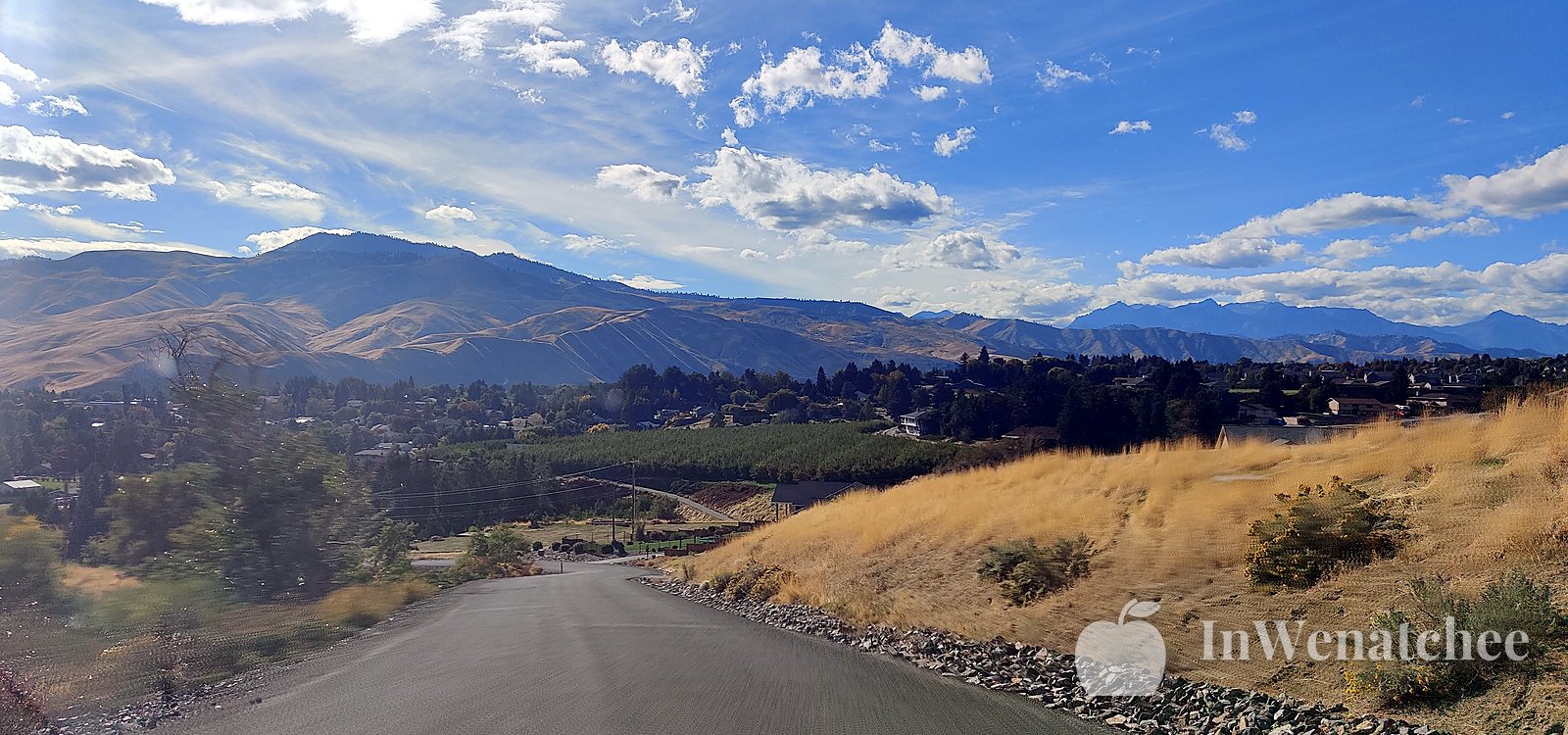 A road winding along a dry hillside above the valley.
