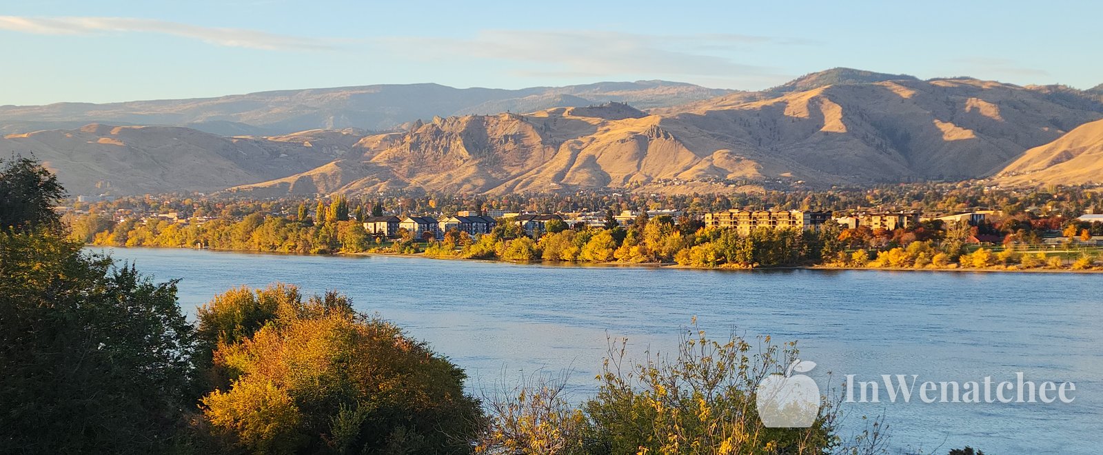 View over the Wenatchee valley, with fall-colored slopes, the Columbia River, and mountains in the distance.