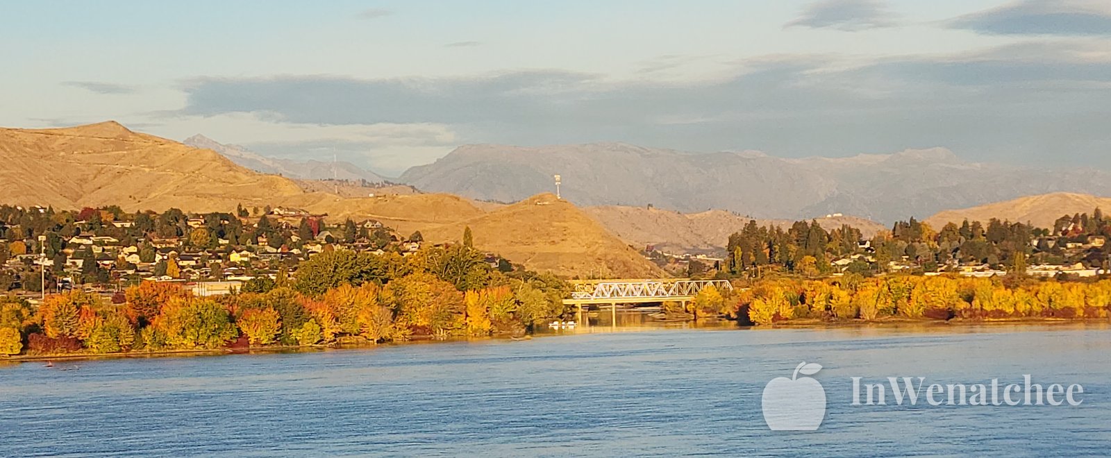 Orange fall hills filling the far side of the Columbia River, above a wide stretch of blue water.